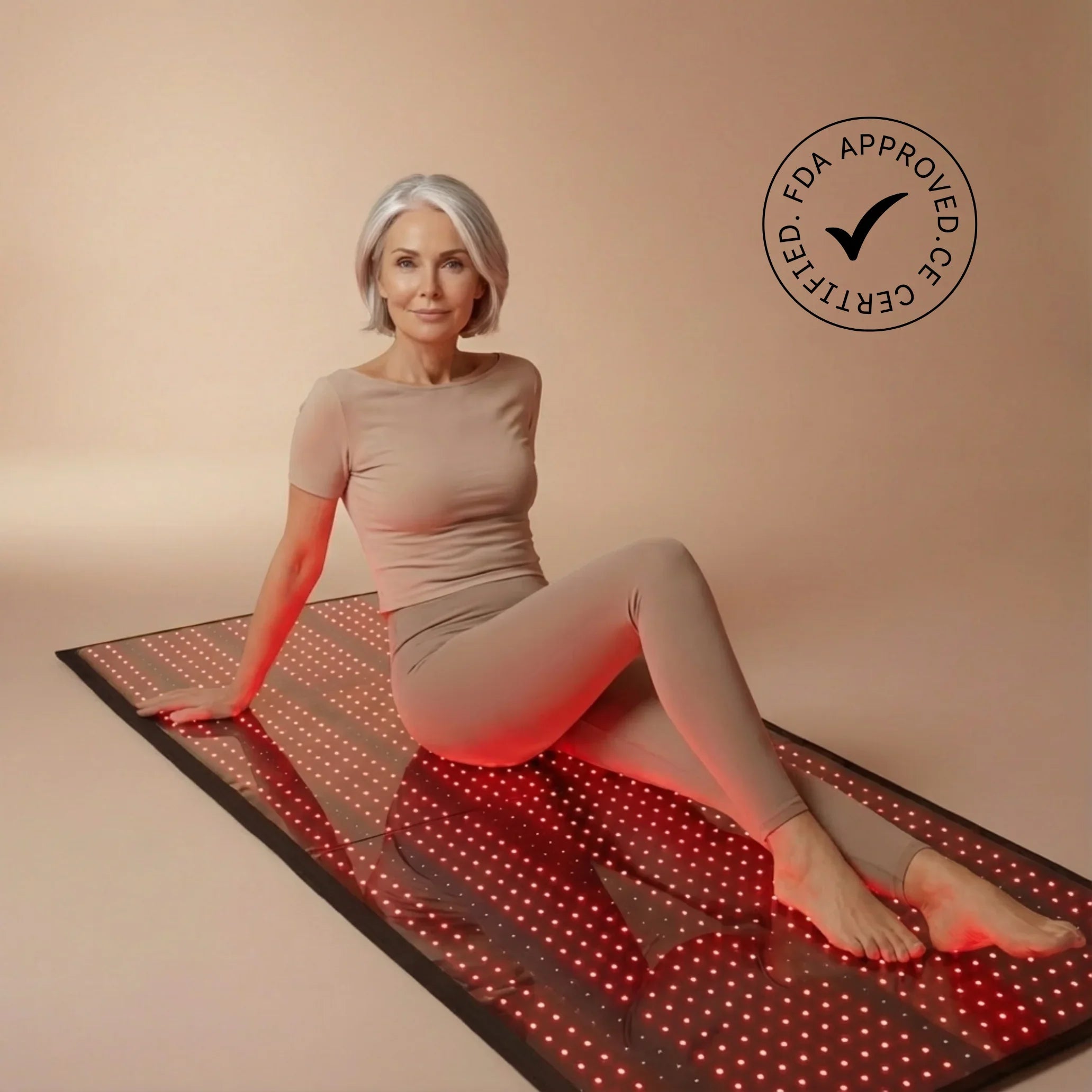 Woman sitting on a NEO LUMINUS Full Body Red Light Therapy Mat
